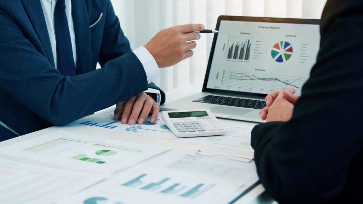 Grupo de pessoas de negócios analisando um relatório gráfico de resumo, aplicando machine learning para melhorar a precisão da análise de dados.
